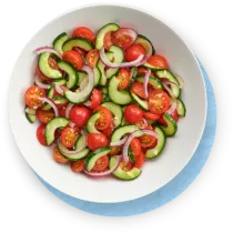 Close up cucumber salad in a white bowl on blue background.