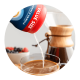 Polvo que se vacía desde una lata en una taza de café cerca de una cafetera que está sirviendo.